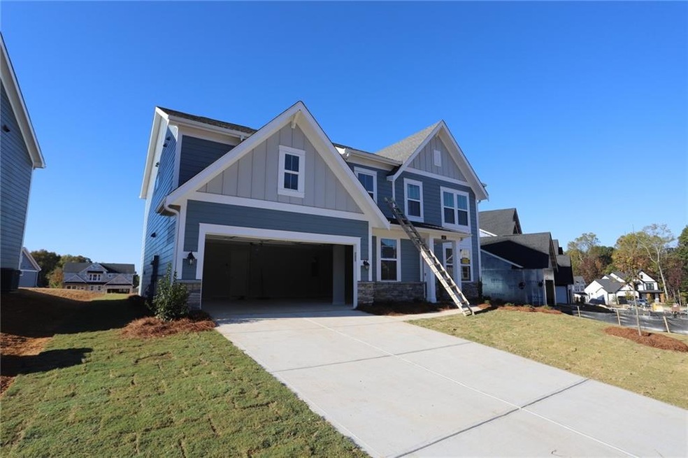 View of front facade featuring a front yard and a garage