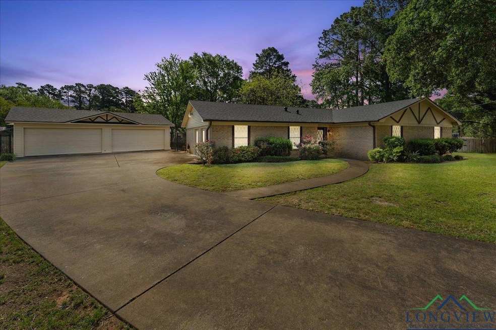 Single story home with a garage, brick siding, a f
