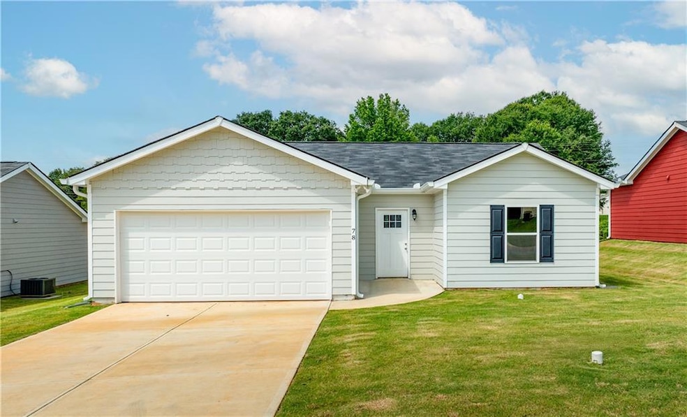 Ranch-style home featuring a front lawn, concrete driveway, an attached garage, and roof with shingles