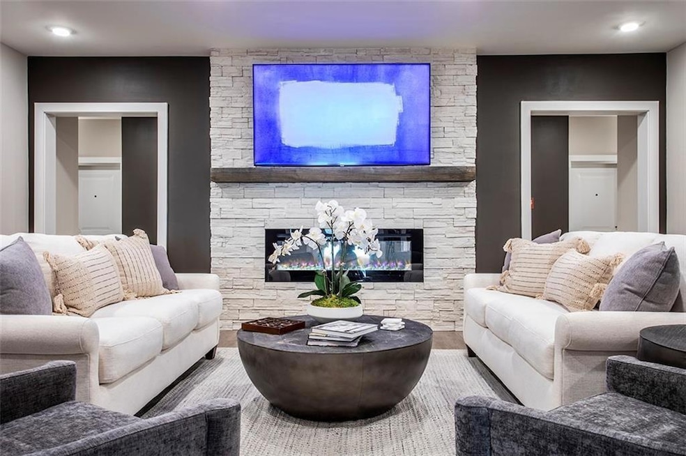 Living area with a stone fireplace and wood finished floors