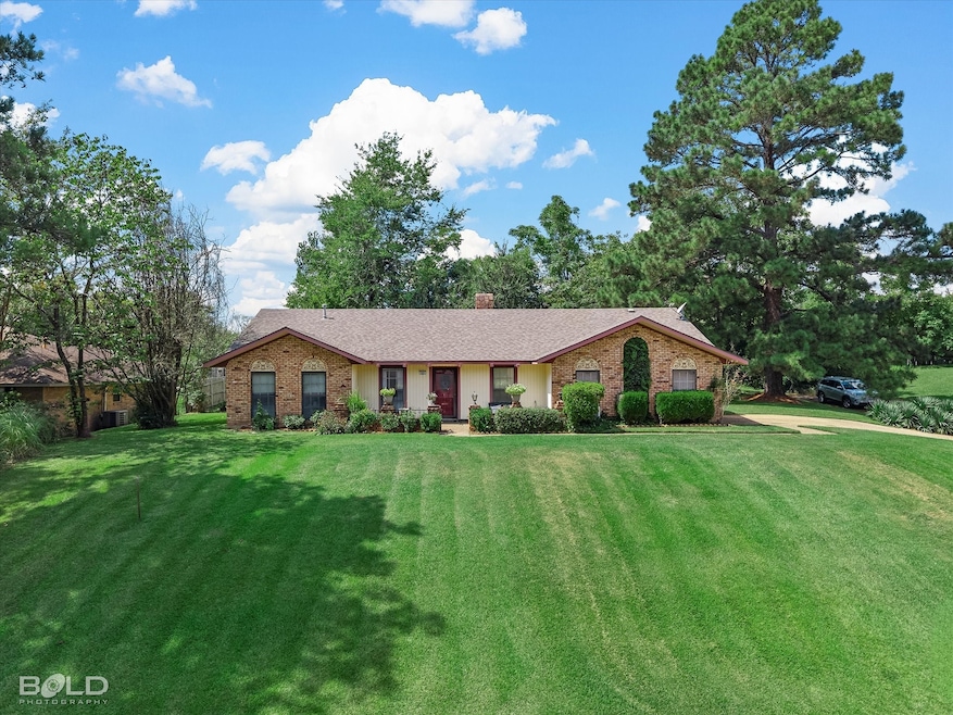 Ranch-style home featuring a front lawn, brick siding, and a chimney