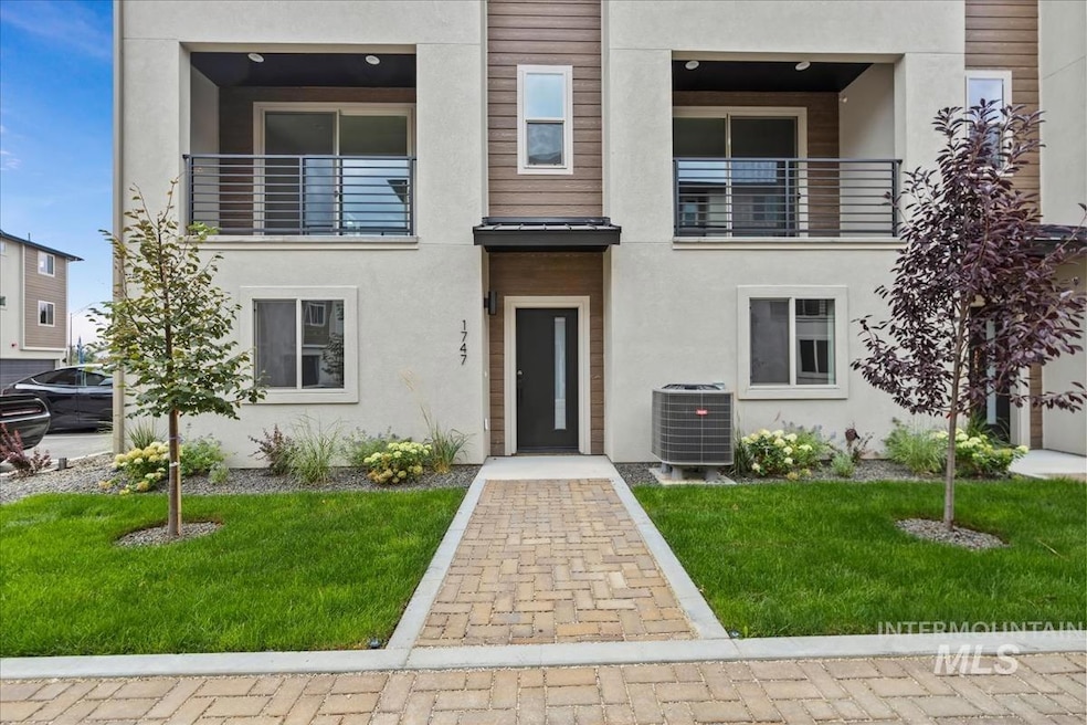 Contemporary home with a balcony, a front yard, and stucco siding