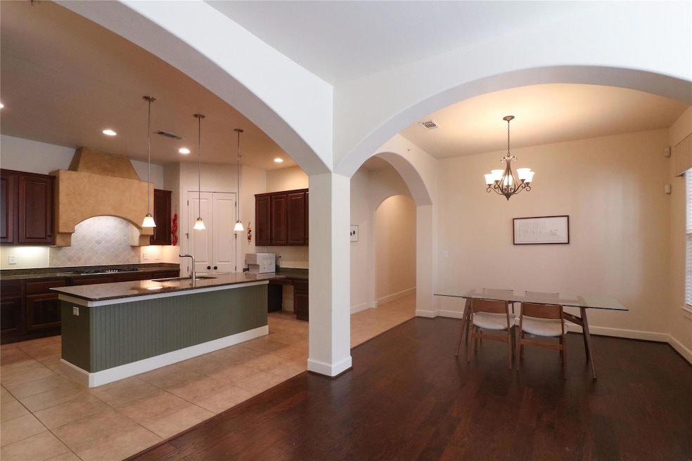 Kitchen with custom exhaust hood, tasteful backspl