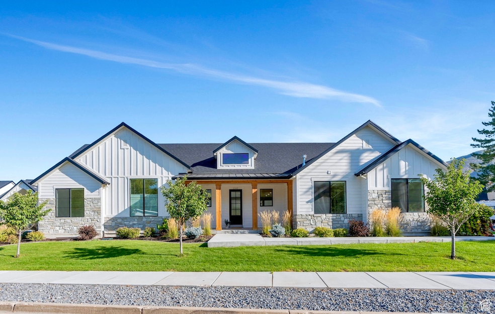 Modern farmhouse with stone,  board and batten siding, and large welcoming front porch
