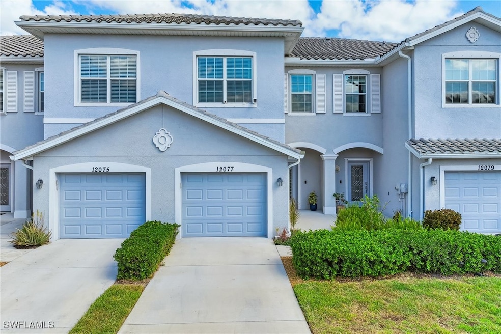 View of property featuring a garage, stucco siding