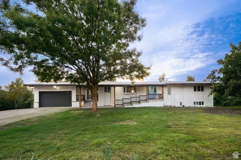 Ranch-style home with a front lawn, concrete driveway, a porch, a garage, and brick siding