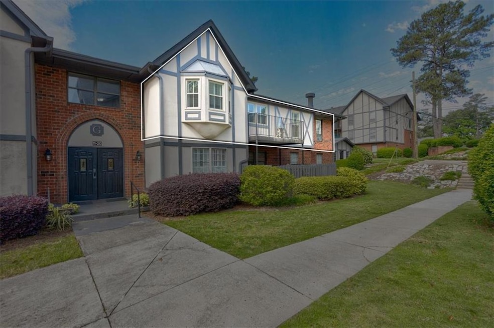 English style home featuring stucco siding, a front yard, and brick siding