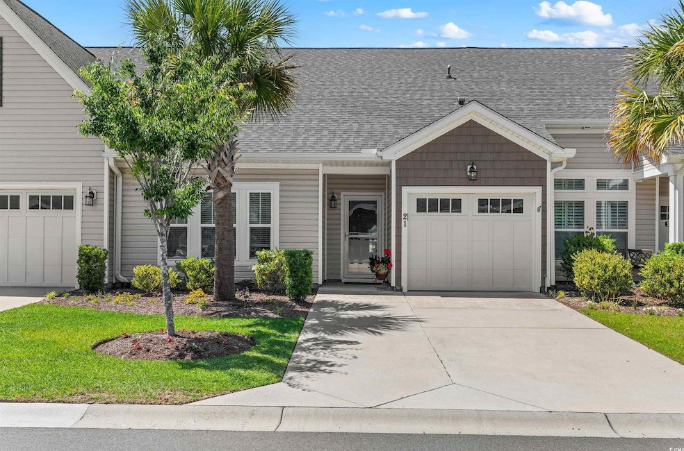View of front of house featuring concrete driveway, a garage, and a shingled roof