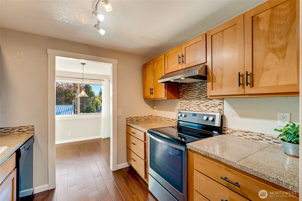 Galley kitchen with light wood and all black appliances give the kitchen beautiful contrast.