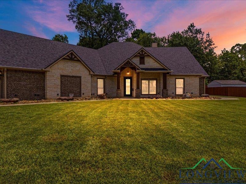Craftsman-style home featuring a chimney, roof with shingles, and stone siding