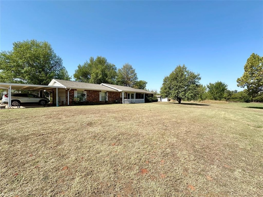 View of front facade with a carport and a front ya