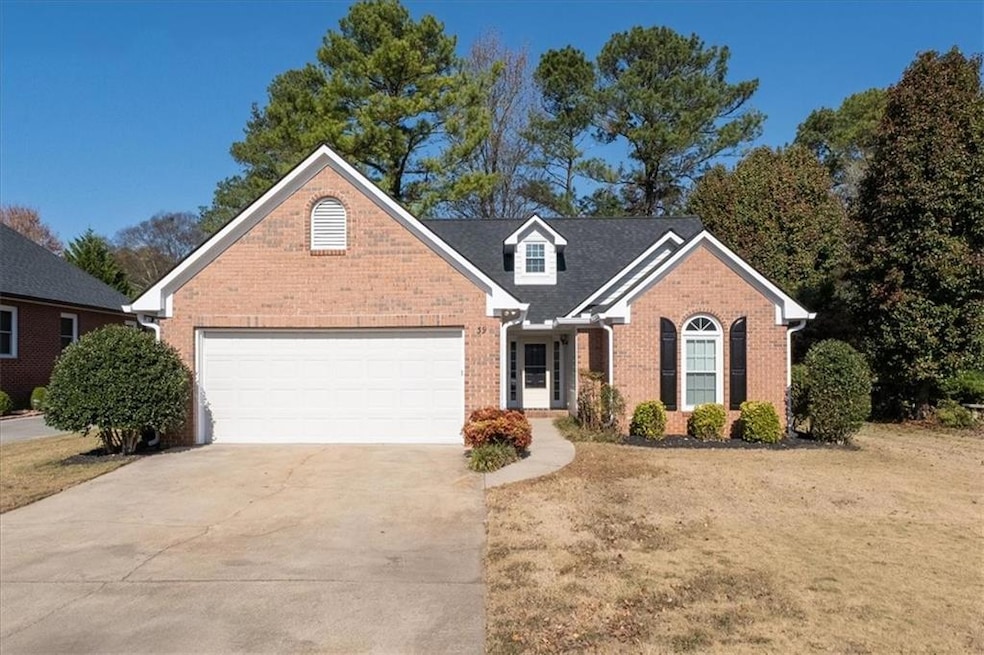 Traditional-style home with brick siding, driveway, an attached garage, and a front yard
