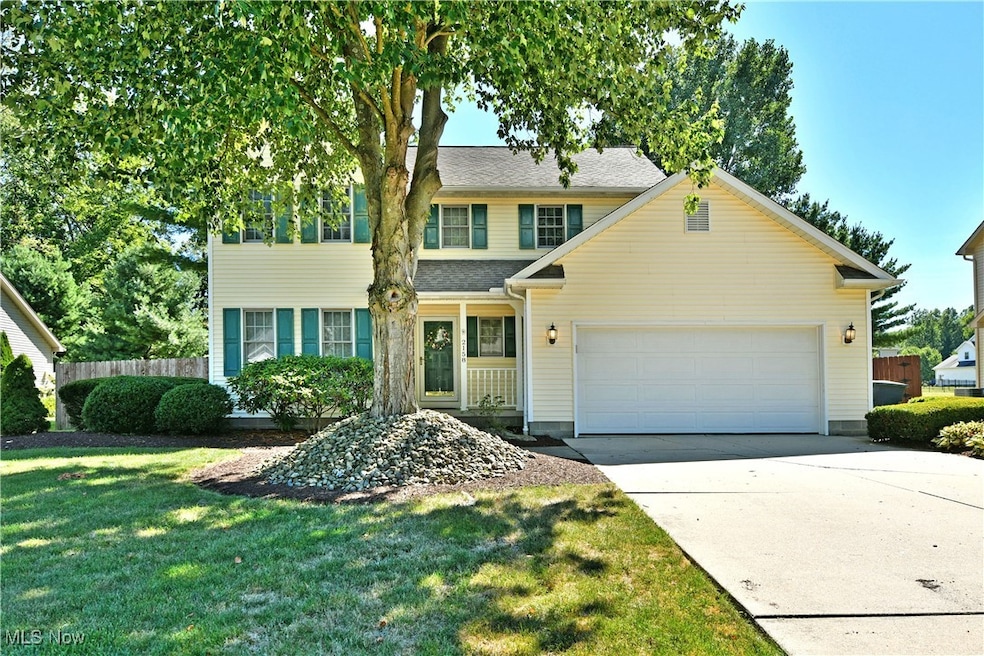 Traditional home featuring a garage, driveway, and a porch