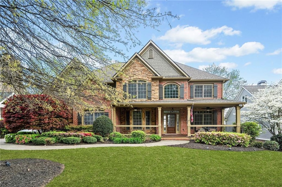 View of front of house with roof with shingles, brick siding, a front lawn, and covered porch
