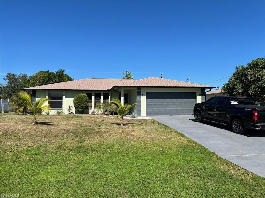Single story home featuring a front lawn, concrete driveway, an attached garage, and stucco siding