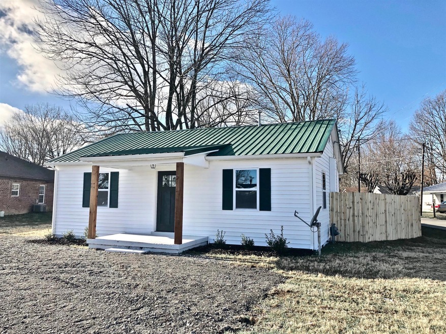 Front exterior features new landscaping, driveway, porch columns, front door, vinyl, light fixtures, windows, and shutters.
