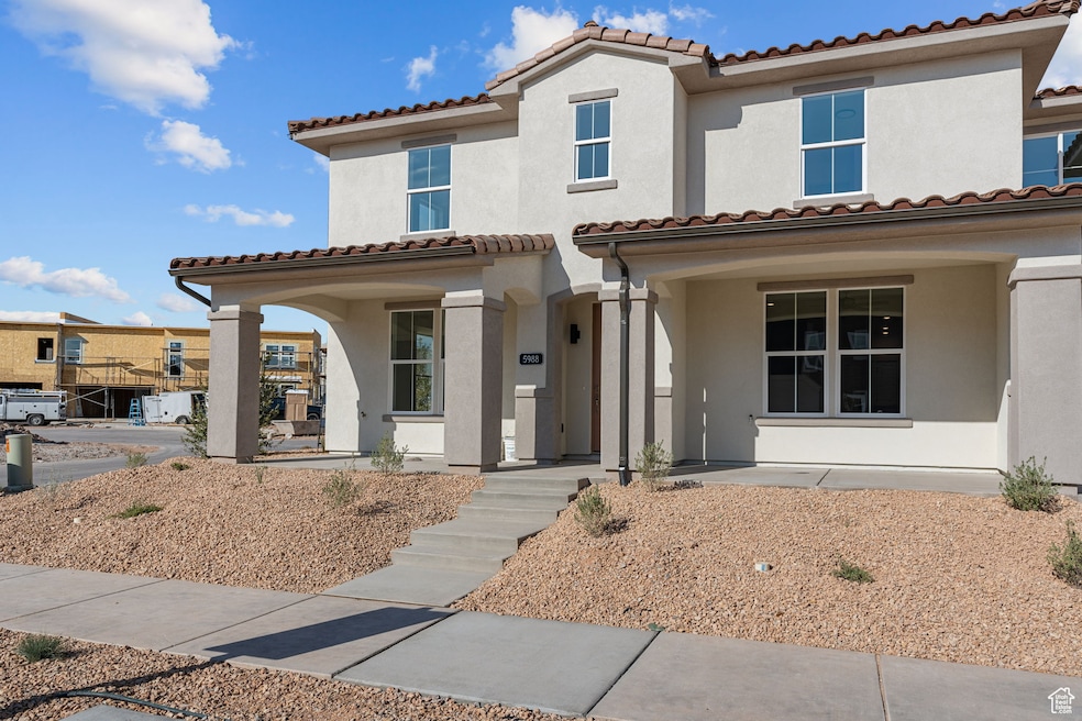 Mediterranean / spanish home with stucco siding, a porch, and a tiled roof