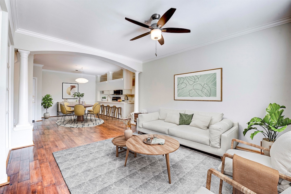 Bright and airy living space with shiny hardwood floors, fresh neutral walls, and sleek modern fixtures. Crown molding throughout adds a nice finishing touch