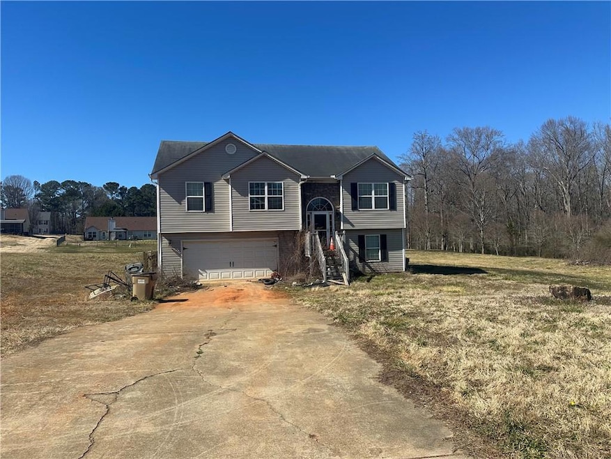 Raised ranch featuring concrete driveway and an at