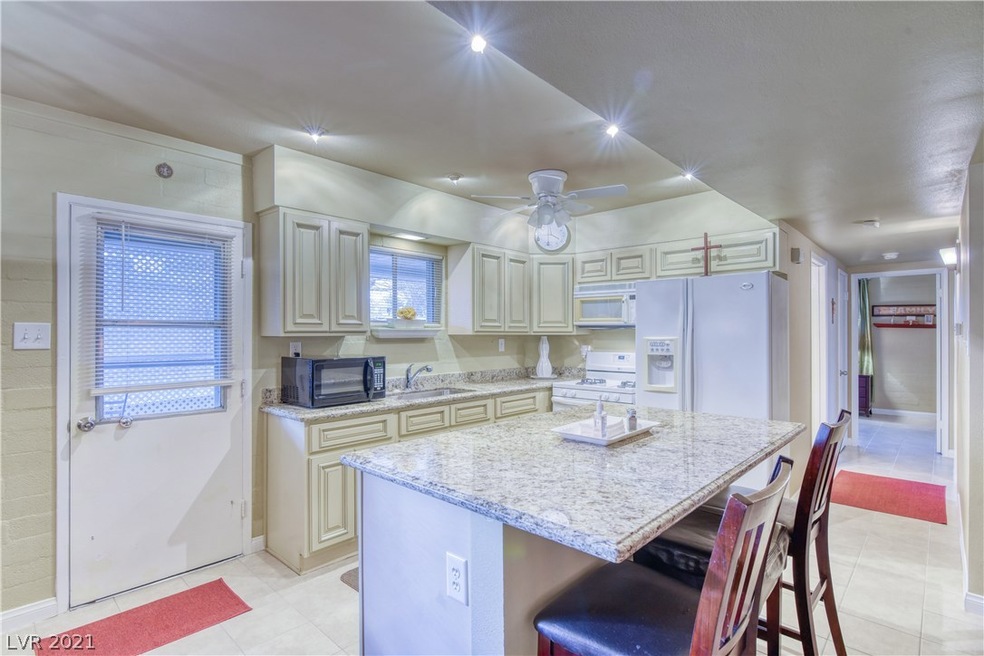 Island kitchen featuring granite counters, custom