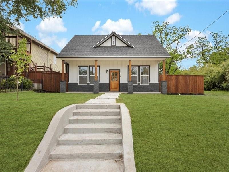 Bungalow-style home with fence, a shingled roof, a