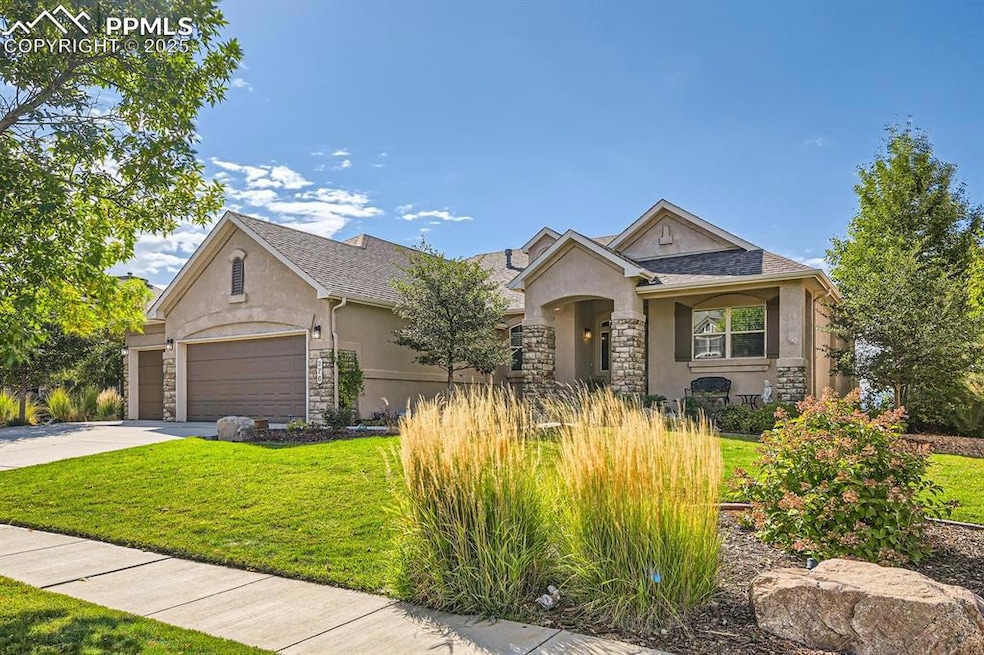 View of front of property featuring a garage and a front yard