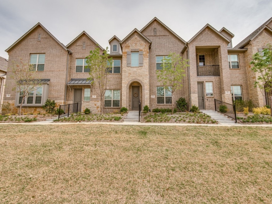 Traditional-style house featuring brick siding, a front lawn, and a balcony