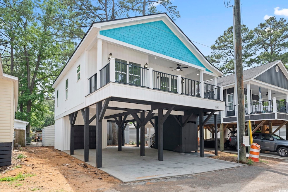 Coastal home with ceiling fan, a carport, driveway