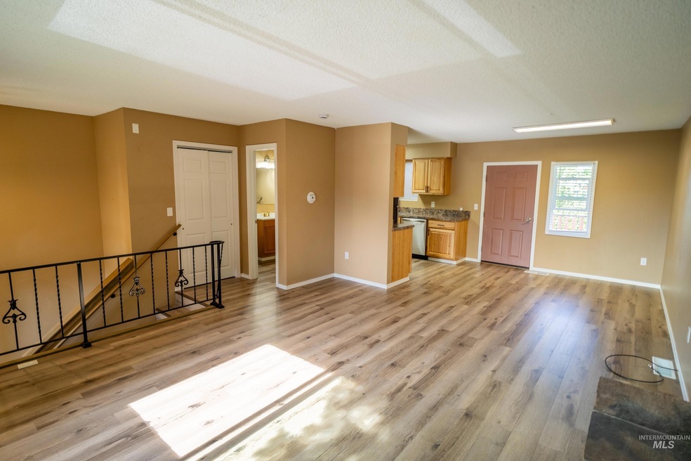 Unfurnished living room with light wood finished floors and a textured ceiling