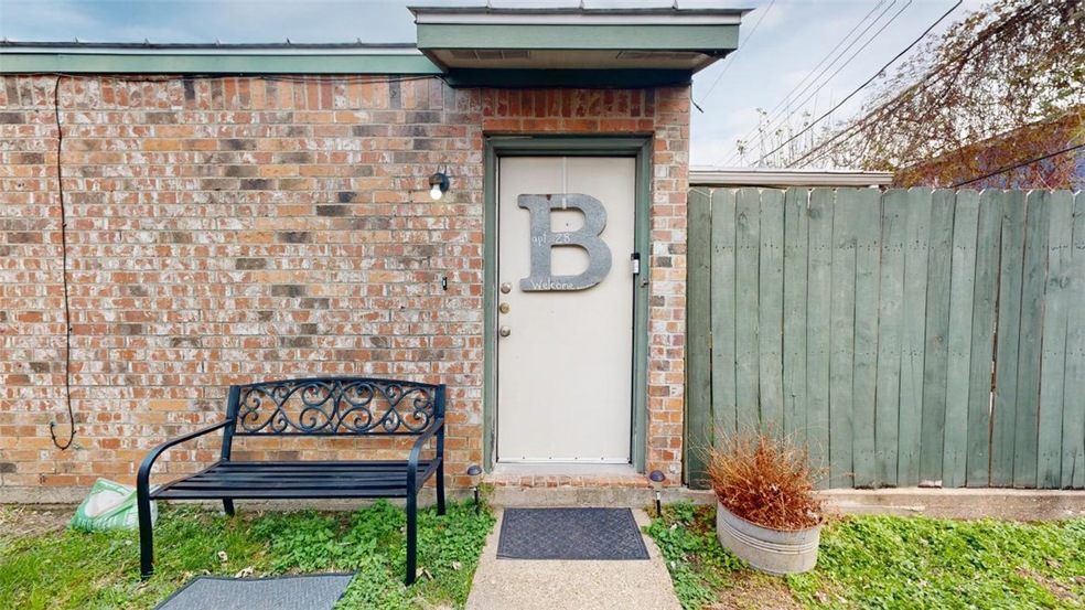 View of exterior entry with brick siding and fence