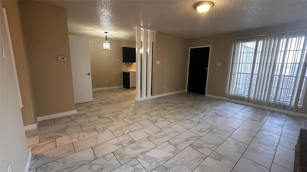 Spare room with a textured ceiling and light marb