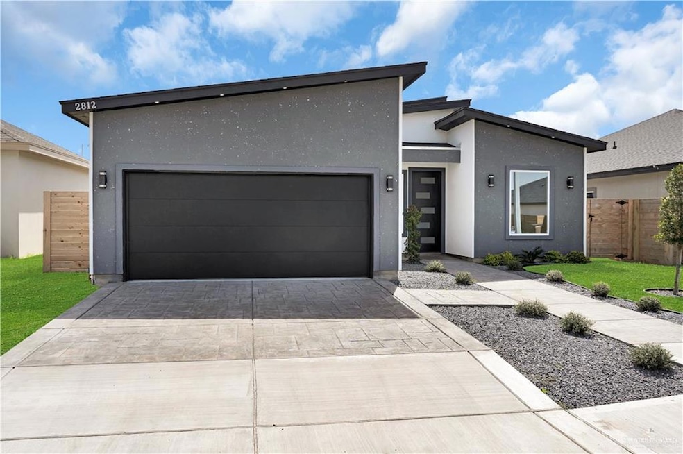Modern home with a garage, stucco siding, and driveway