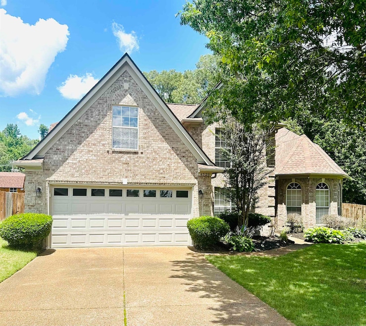 Traditional home featuring driveway and brick siding