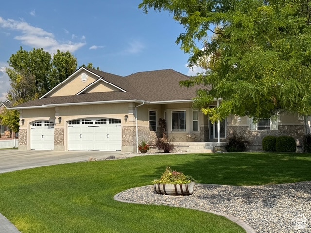View of front of property with a front lawn, driveway, a garage, stucco siding, and roof with shingles