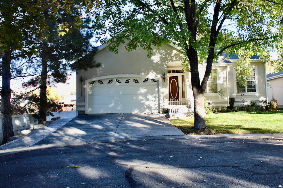 View of front facade with concrete driveway, stucco siding, and an attached garage