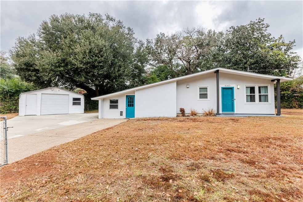 Ranch-style home featuring a garage and an outbuil