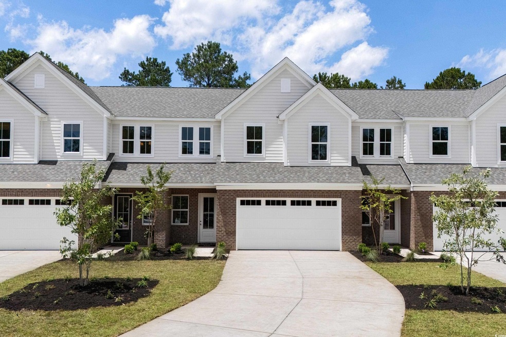 View of front of house with driveway, brick siding, roof with shingles, and a front yard