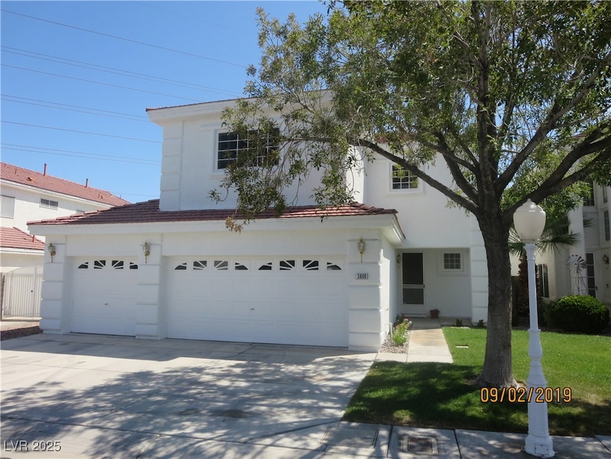 View of front of property featuring concrete driveway, stucco siding, an attached garage, a front yard, and a tile roof