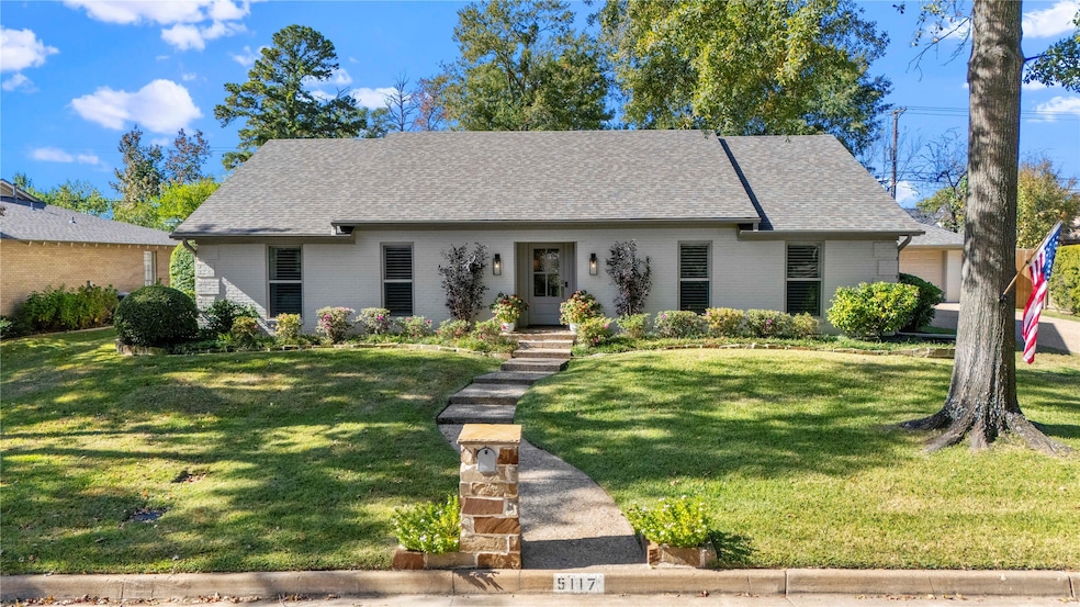View of front facade with a front lawn, brick siding, and roof with shingles