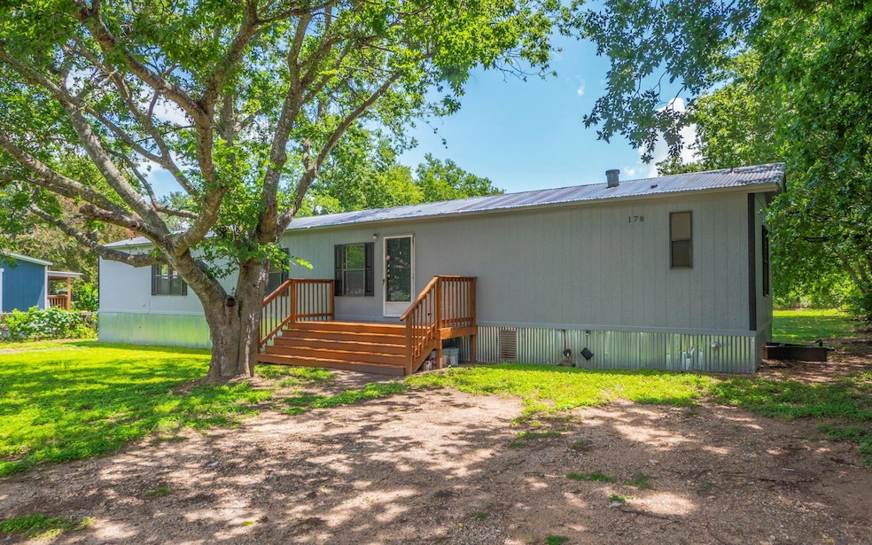 Back of house featuring a metal roof and a yard