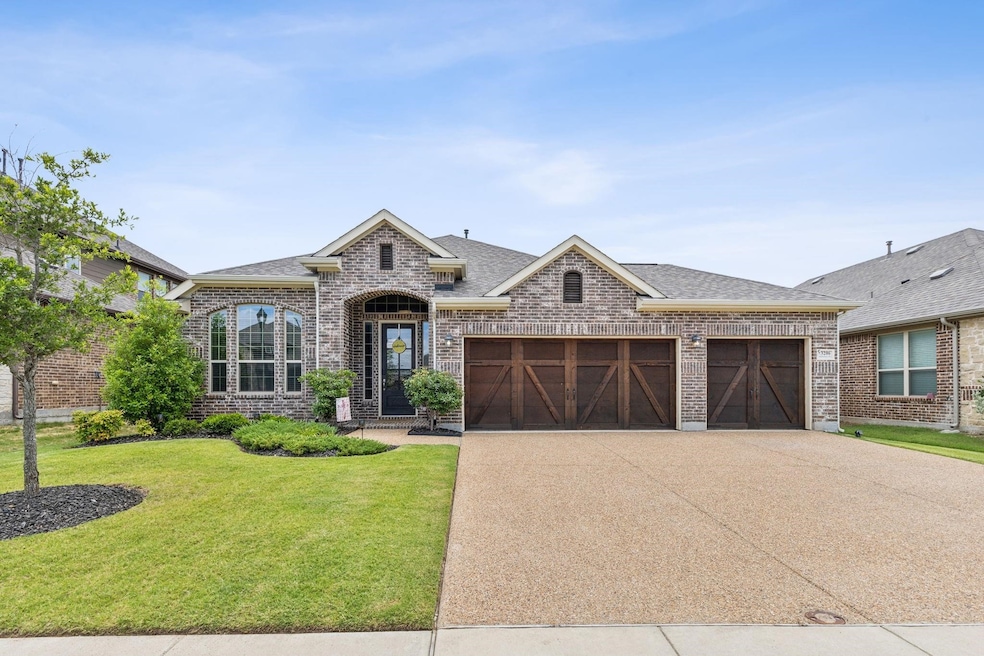 French country inspired facade with a front yard and a garage