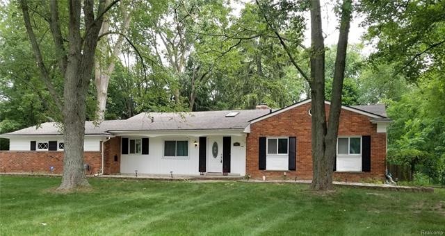Lovely ranch w/side entry garage on a large wooded