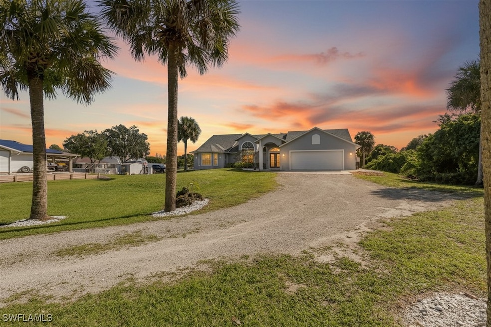 View of front facade featuring driveway, a front yard, and a garage