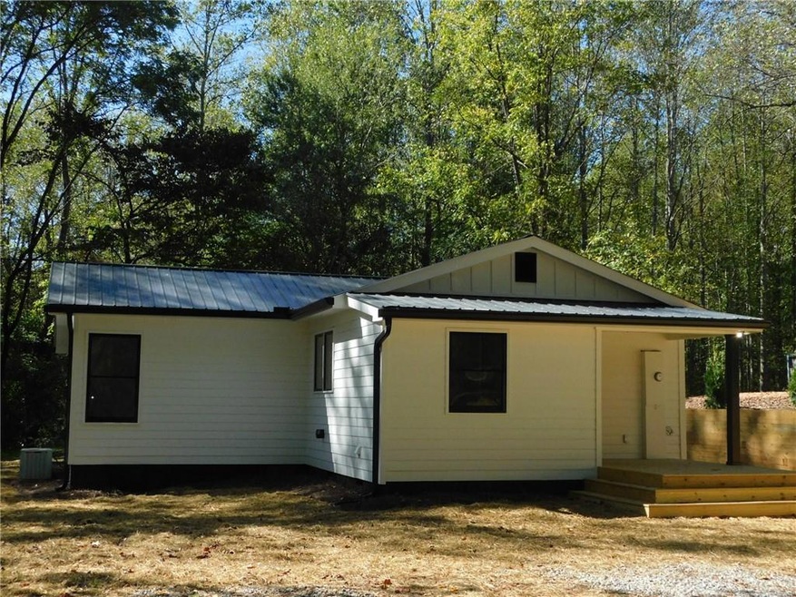 Rear view of property with cooling unit and a deck