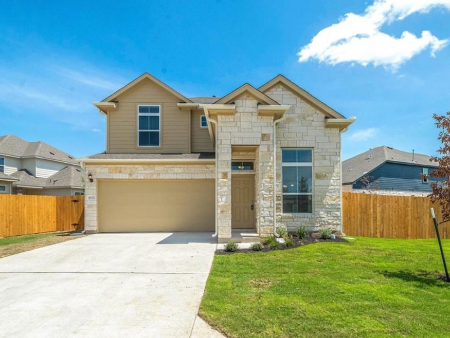 View of front of home featuring stone siding, a g