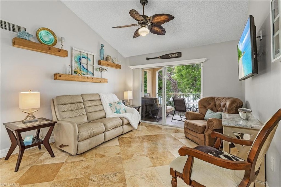 Living area with lofted ceiling, ceiling fan, and a textured ceiling