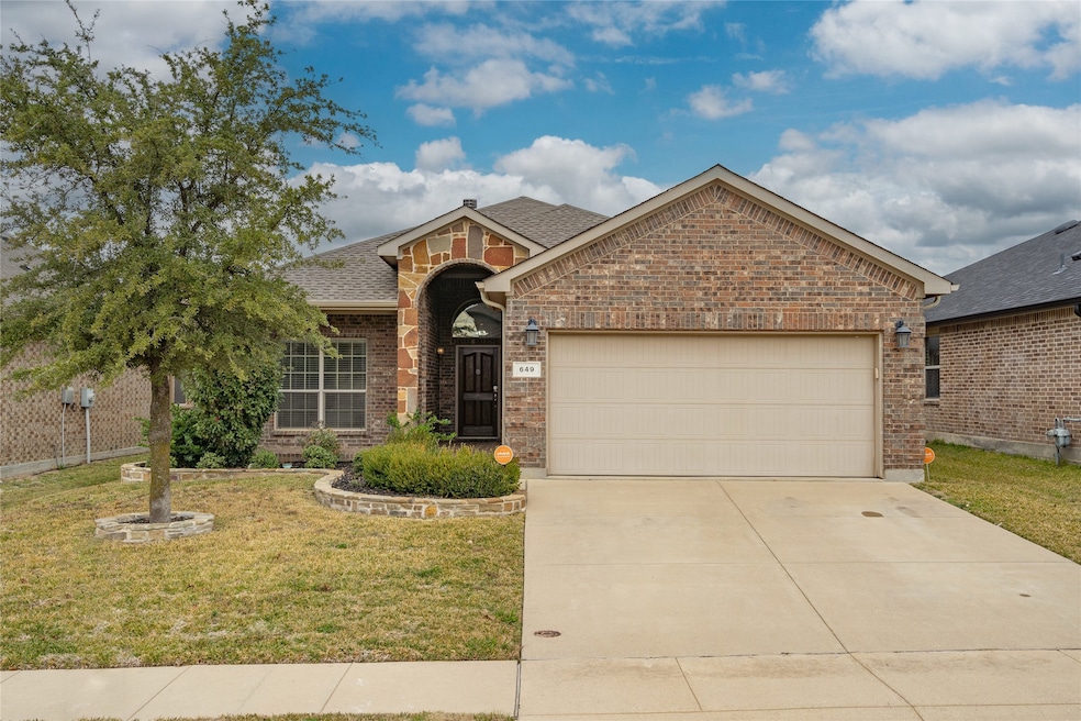 View of front facade with brick siding, an attached garage, a front lawn, driveway, and a shingled roof