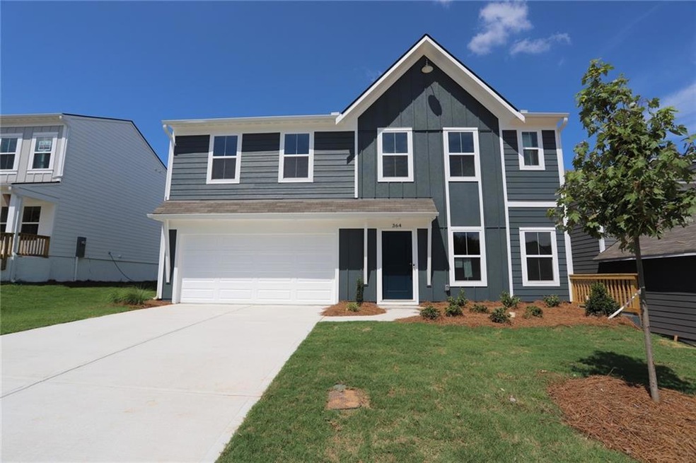 View of front of home with a front yard and a garage