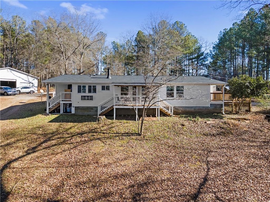 Rear view of property with a yard, a garage, and a