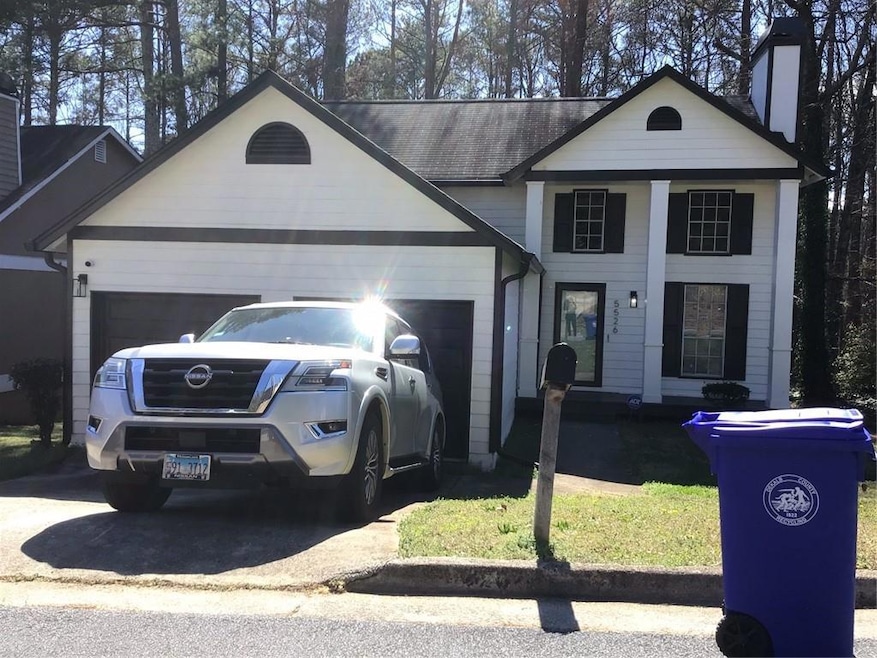 View of front of house featuring a garage and a ch